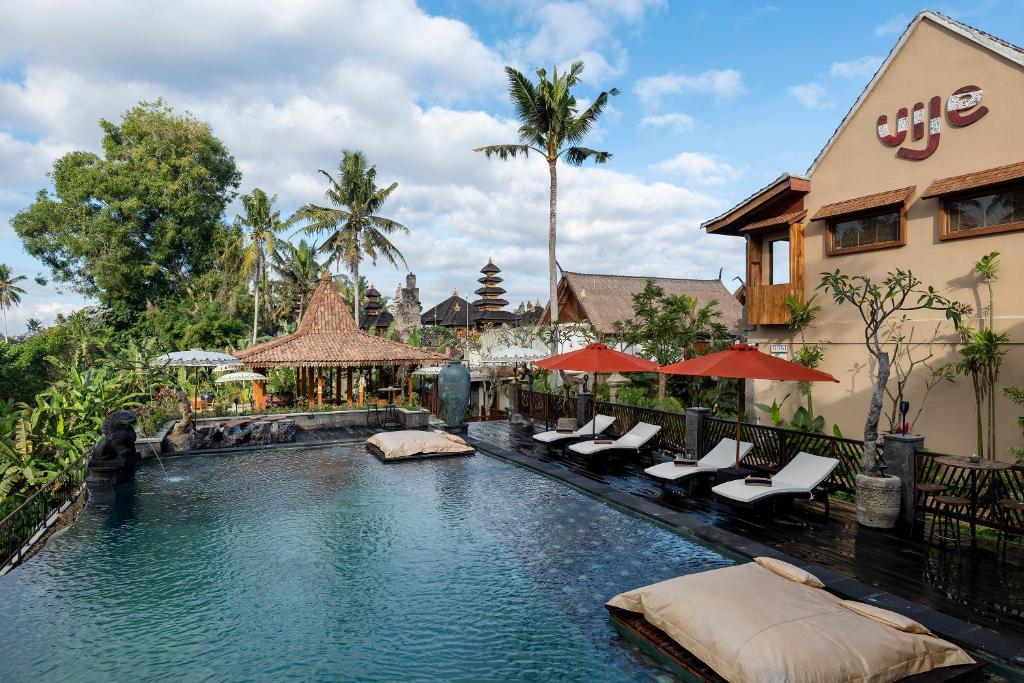 a swimming pool at a resort with lounge chairs at Vije Boutique Resort & Spa in Ubud