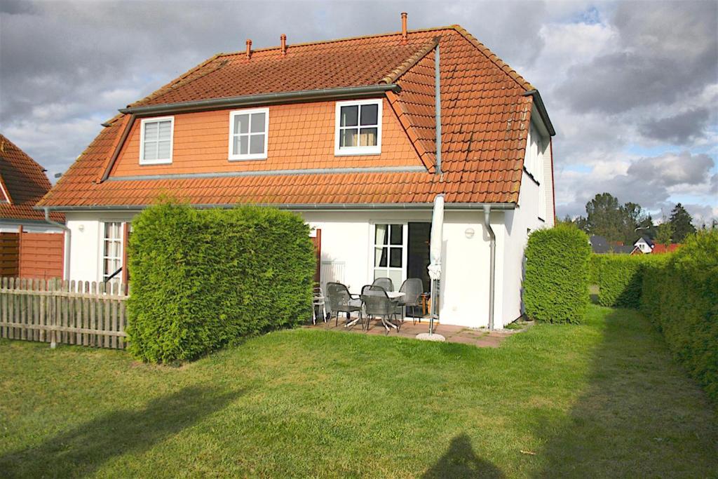 a white house with an orange roof at Kranichwiese FW 1 in Zingst