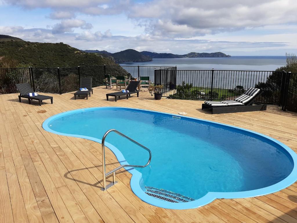a large blue swimming pool on a wooden deck at The Kereru's Nest in Kaeo