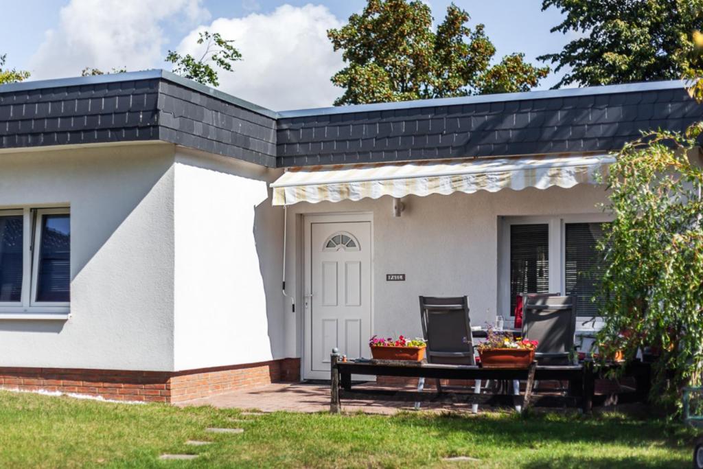 a white house with a black roof and a patio at Haus Paul in Grömitz