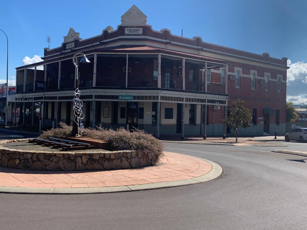 a large red brick building on a street corner at Premier Hotel Collie in Collie