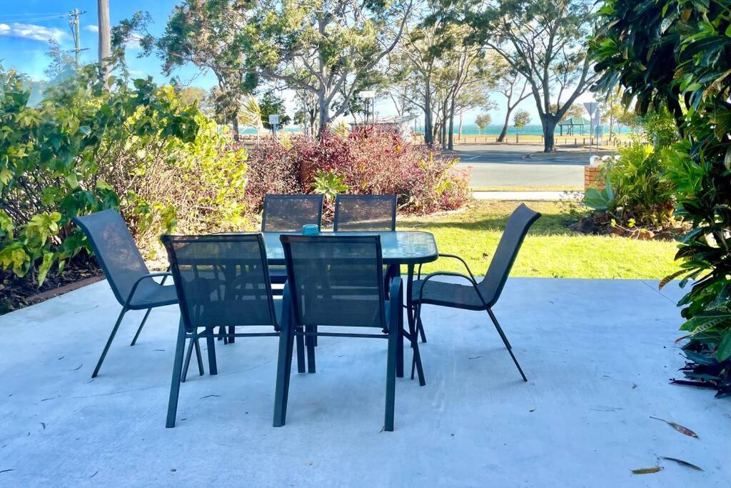 a table with four chairs around it in a park at WHISPERING PALMS in Bongaree