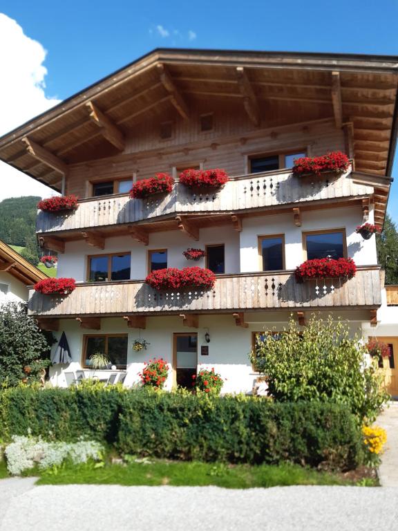 un edificio con flores rojas en los balcones en Haus Roland, en Zell am Ziller