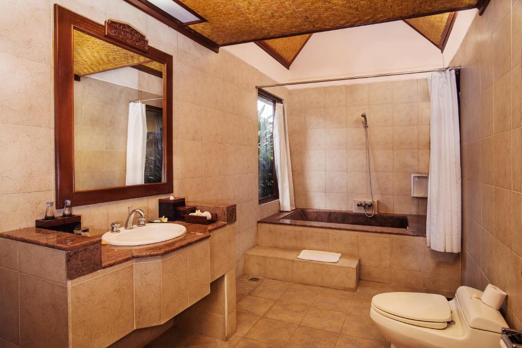 a bathroom with a sink and a toilet and a tub at Sri Phala Resort & Villa in Sanur