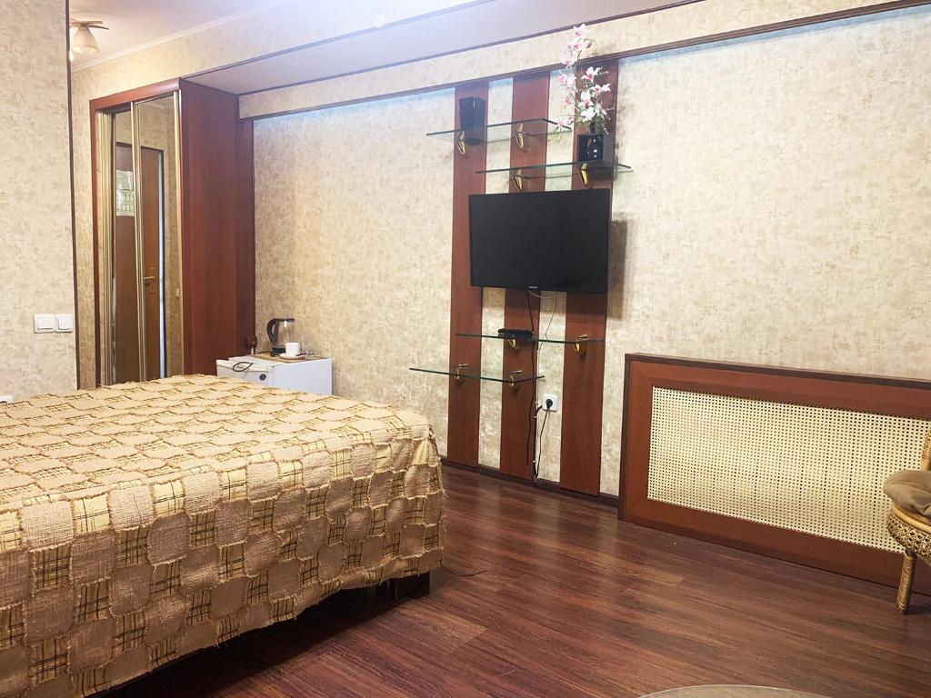 a hotel room with a bed and a flat screen tv at Mercury Hotel Complex in Nakhodka