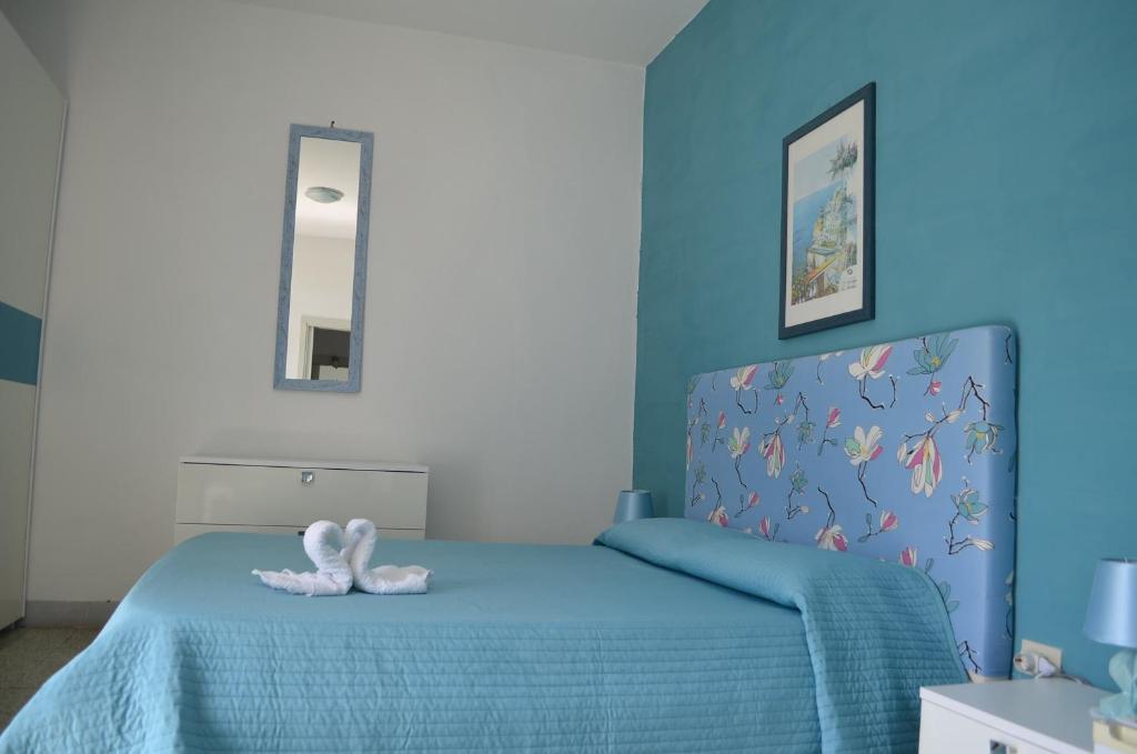 a bedroom with a blue bed with two white towels at Palazzo Della Marra in Ravello