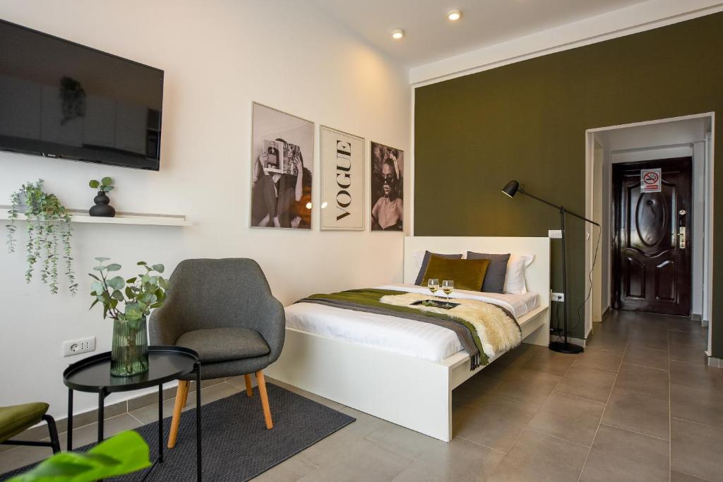 una camera da letto con un letto, una sedia e un tavolo di Classy Comfort - Chic Studio on Regina Elisabeta a Bucarest