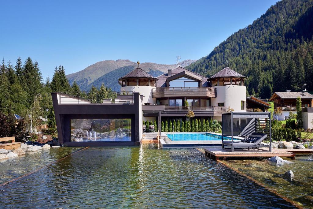 a house on the water with a swimming pool at FONTIS luxury spa lodge in Santa Maddalena in Casies Valbassa