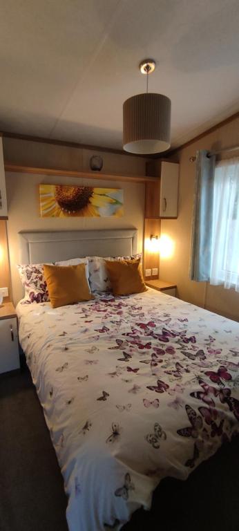 a bedroom with a large bed with flowers on it at The Wright Holiday Home in Forfar