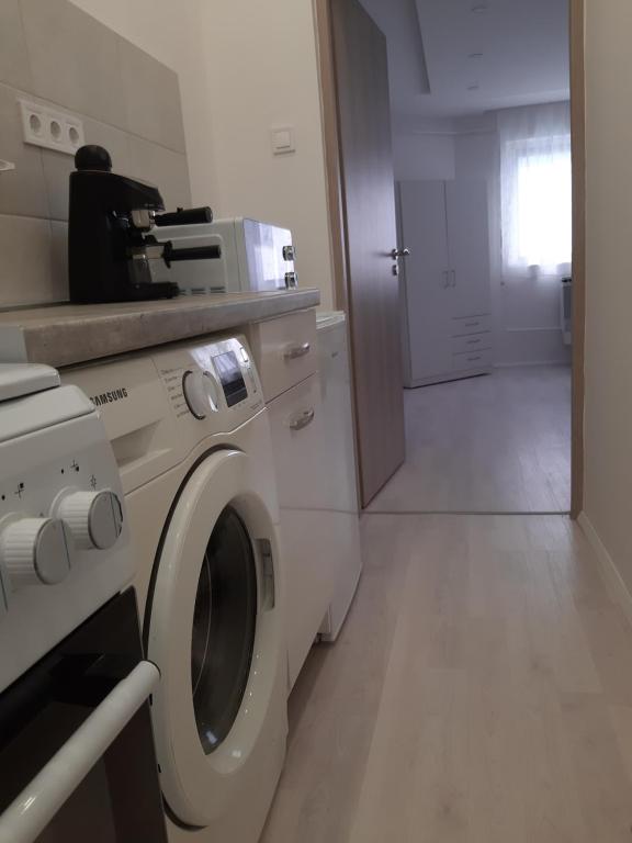 lavadero con lavadora y pasillo en Belvárosi Apartman Vásárosnamény, en Vásárosnamény