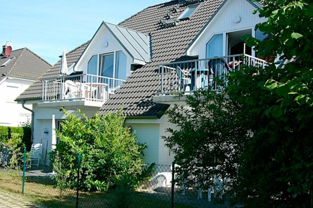 a white house with a porch and a balcony at Strandperle 9, PP außen in Zingst