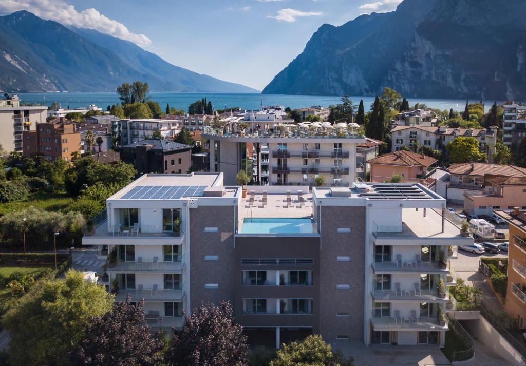 vistas a una ciudad con montañas en el fondo en Aris Apartments & Sky Pool - TonelliHotels, en Riva del Garda