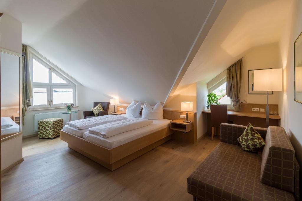 ein Hotelzimmer mit einem Bett und einem Sofa in der Unterkunft Gästehaus Burgblick in Bisingen