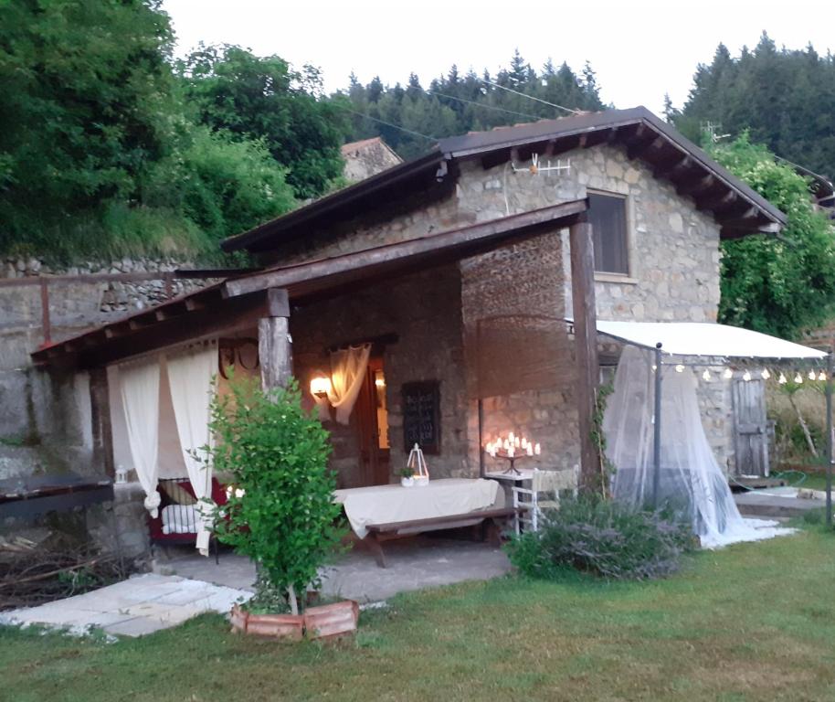 a stone house with a bath tub in the yard at L'Essiccatoio in Fivizzano
