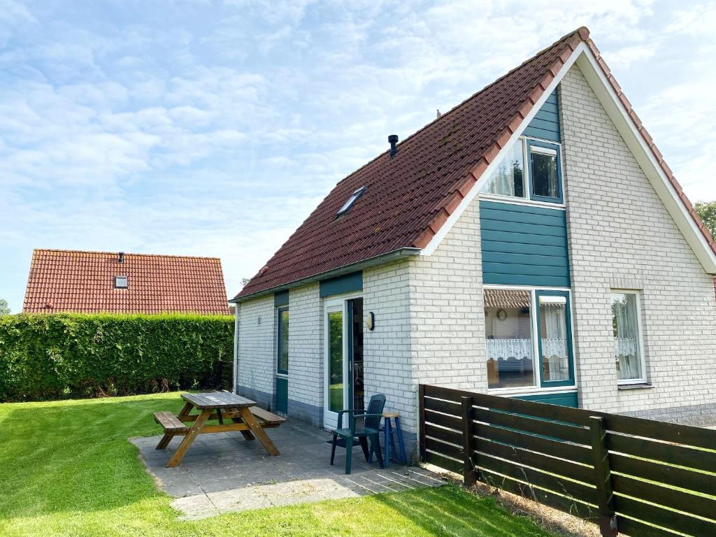 a small house with a picnic table and a bench at Hello Zeeland - Vakantiehuis Stern 202 in Breskens