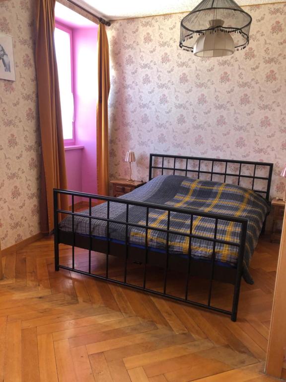 a bedroom with a black bed in a room at Chambres d'Hotes Le Passiflore in Les Brenets