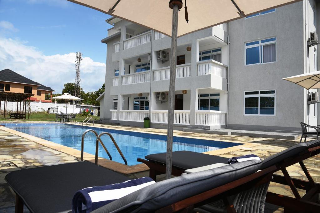 a view of a swimming pool and a building at ENZI FURNISHED APARTMENT DIANI in Ukunda