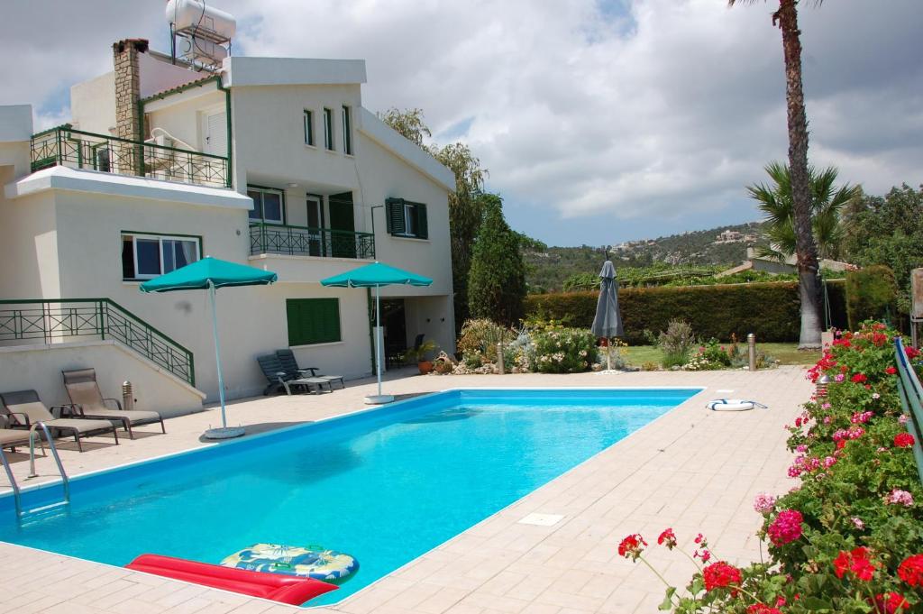 a villa with a swimming pool and a house at Villa Chrysanthia in Polis Chrysochous