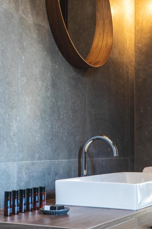 a bathroom with a white sink and a mirror at DESIGN hotel VERBENICUM in Vrbnik