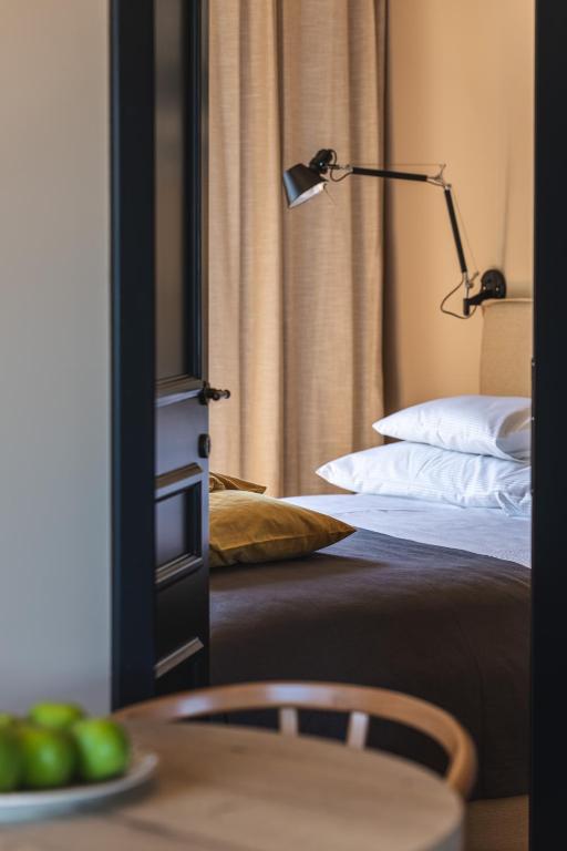 a hotel room with a bed and a table with a lamp at DESIGN hotel VERBENICUM in Vrbnik