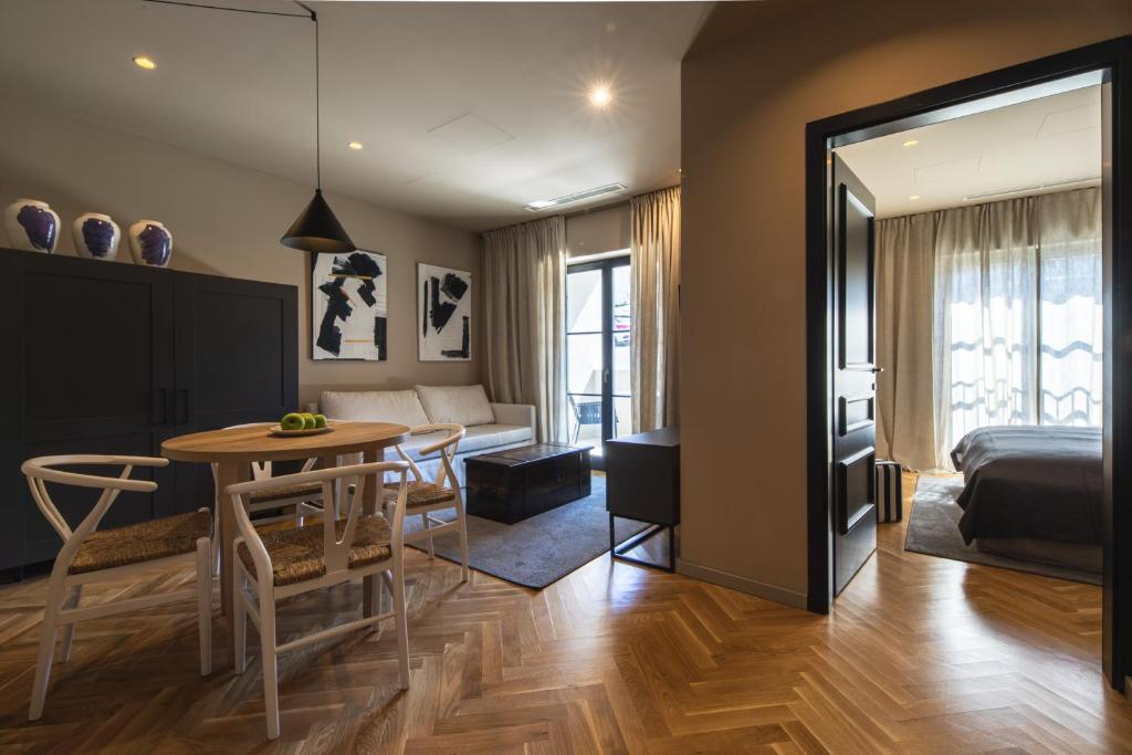 a bedroom and living room with a table and a bed at DESIGN hotel VERBENICUM in Vrbnik