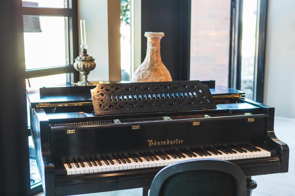 a black piano sitting on a table with a vase at DESIGN hotel VERBENICUM in Vrbnik