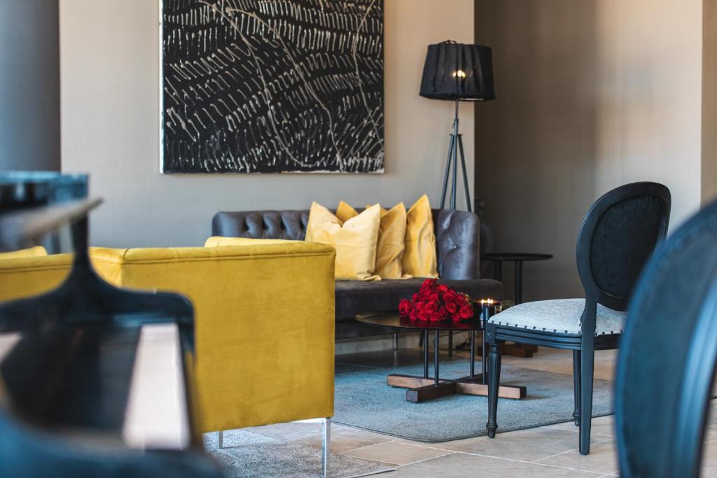 a living room with a couch and a table and chairs at DESIGN hotel VERBENICUM in Vrbnik