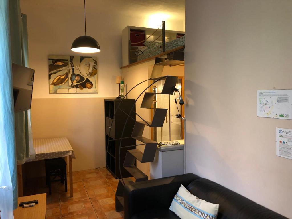 a living room with a black couch and a staircase at Estudio Finestrelles in Barcelona