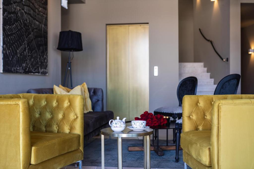 a living room with two yellow chairs and a table at DESIGN hotel VERBENICUM in Vrbnik