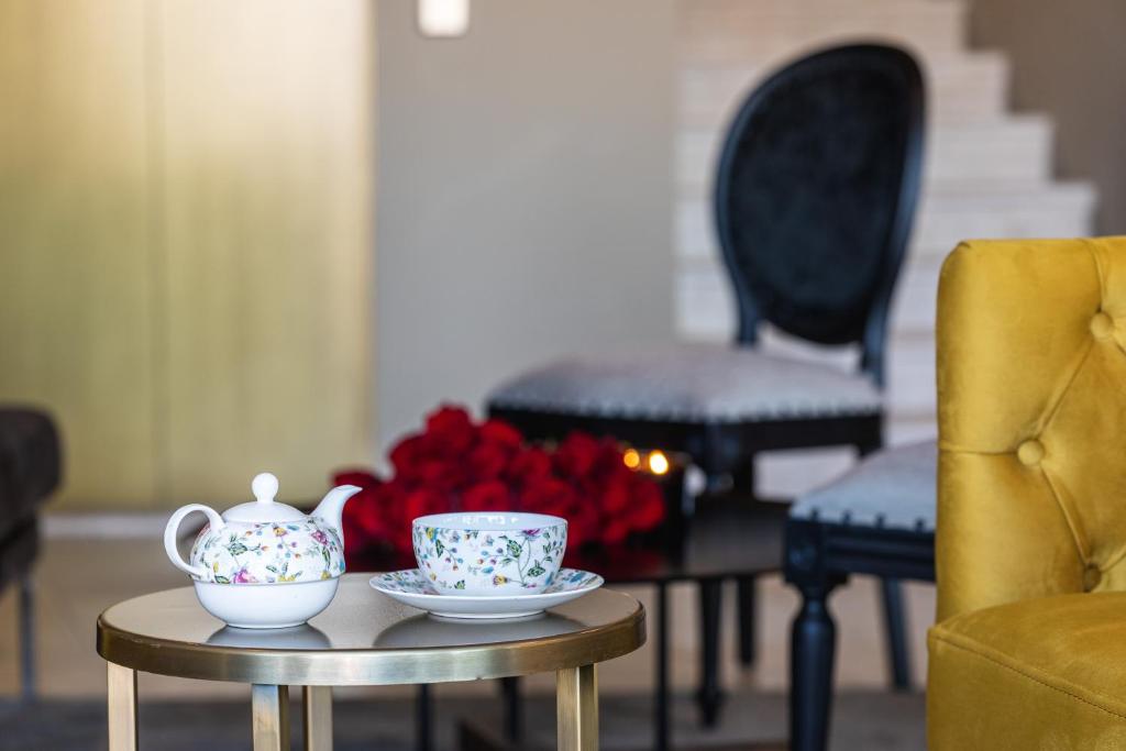 a table with two tea cups and a vase at DESIGN hotel VERBENICUM in Vrbnik