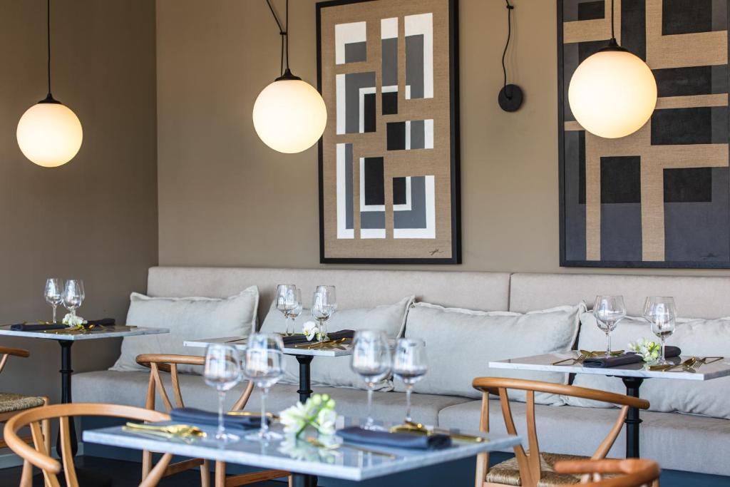 a dining room with tables and chairs with wine glasses at DESIGN hotel VERBENICUM in Vrbnik
