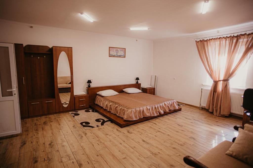 HusyatynЛісова Пісня Апартаменти的一间卧室配有一张床和镜子