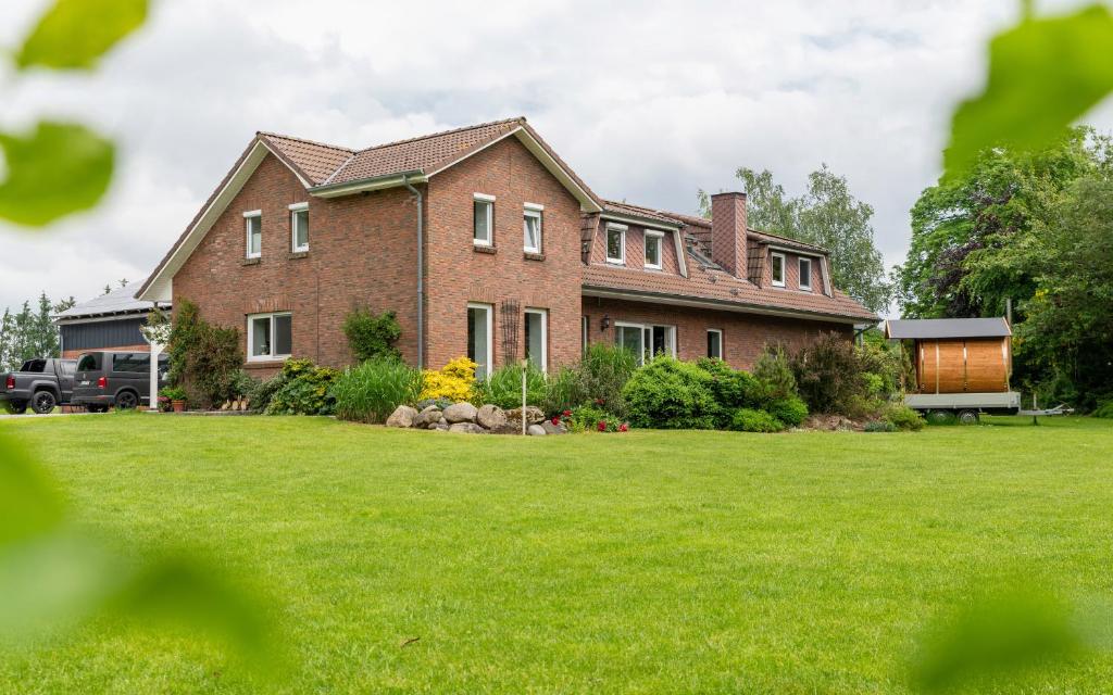 a large brick house with a green lawn at Franzi in Weesby