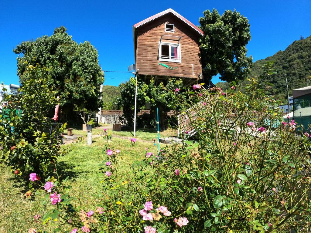 a house in the middle of a garden with flowers at ti kaz perchée in Entre-Deux