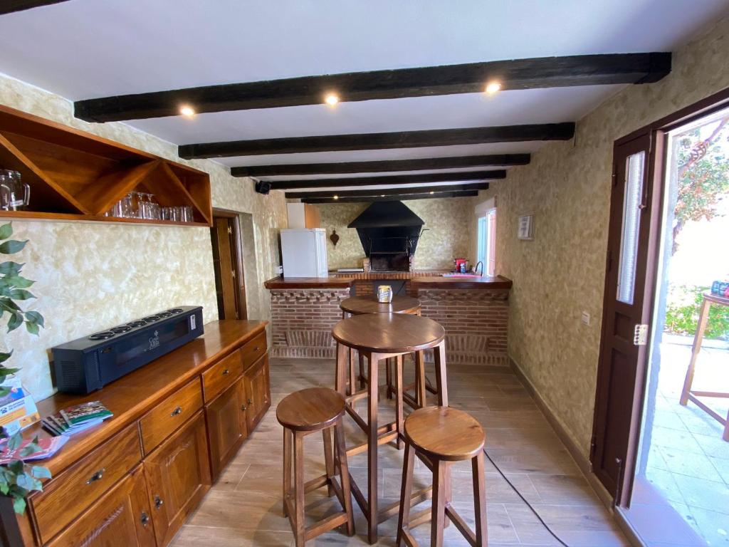 a kitchen with two bar stools and a stove at Casa Tijeras I in Sotillo de las Palomas