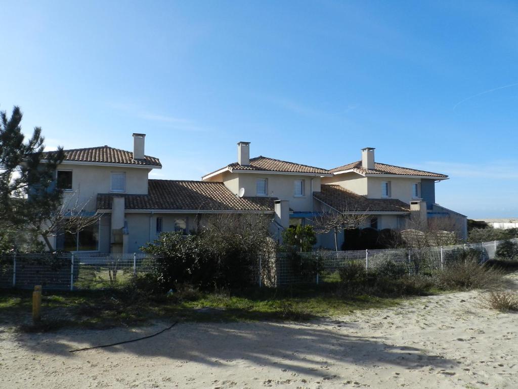 une maison sur la plage à côté d'une clôture dans l'établissement Orée de La Dune, à Biscarrosse-Plage