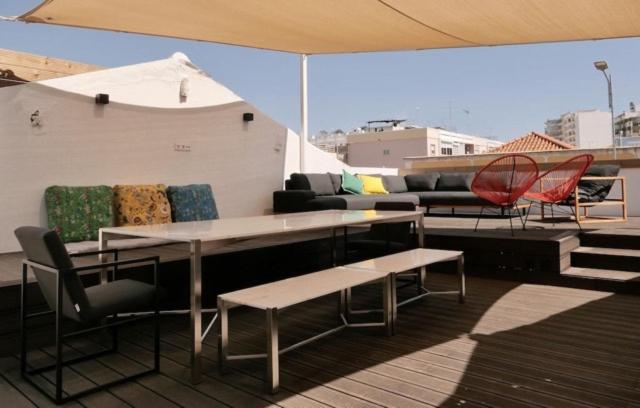 a patio with a couch and tables and chairs at Casa dos Retratos Faro in Faro