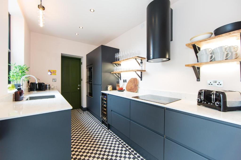 斯基普頓的住宿－Craven by Casa Del Artista - Hosted by Maison Parfaite - 4 Bedroom Luxury House - Skipton，厨房配有蓝色橱柜和绿门