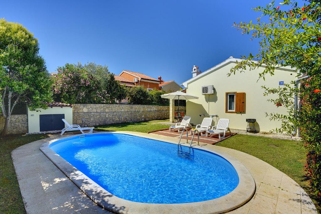 a swimming pool in the backyard of a house at Villa Helena in Banjole