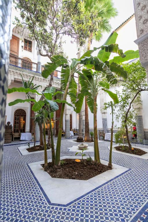 une cour avec des palmiers dans un bâtiment dans l'établissement RIAD LOUDAYA AND SPA, à Fès