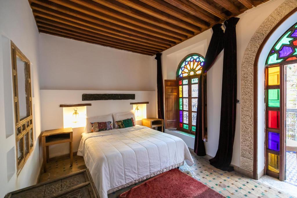 une chambre avec un lit et des vitraux dans l'établissement RIAD LOUDAYA AND SPA, à Fès