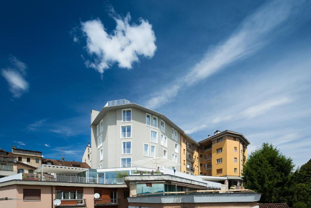 un edificio blanco con una nube en el cielo en Suites Hotel Astor, en Belluno