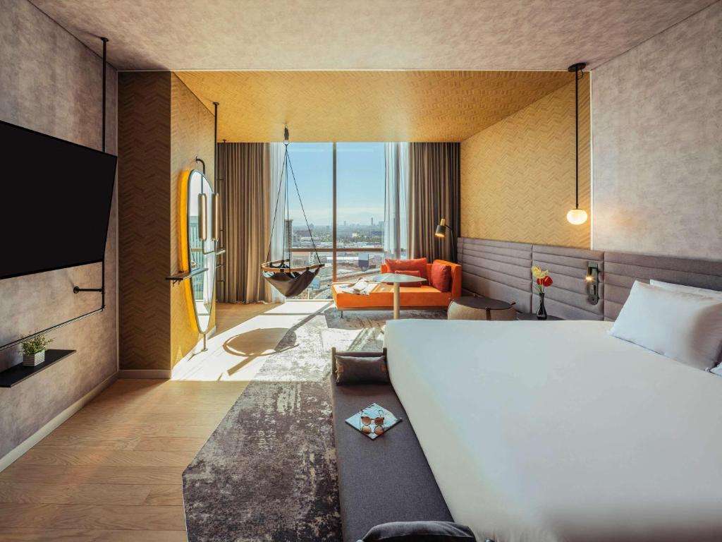 una camera d'albergo con letto e soggiorno di Novotel Mexico City Toreo a Città del Messico