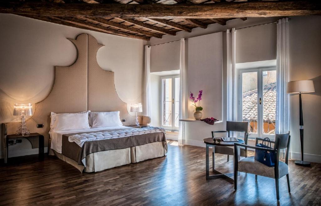 a bedroom with a bed and a table with a chair at 47LuxurySuites - Trevi in Rome