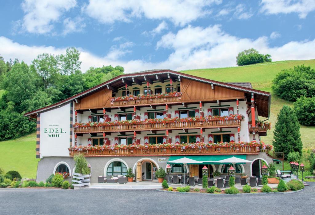 un hotel con un gran edificio con balcón en Hotel Edelweiss, en Braies