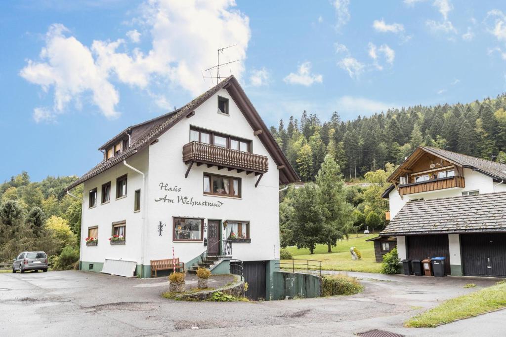 托特莫斯的住宿－Am Wehrastrand Einzelappartment，白色的建筑,上面有在荒野读的地方的标志