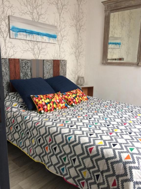 um quarto com uma cama com almofadas coloridas em Le Logis d'Elisa em Cosne Cours sur Loire
