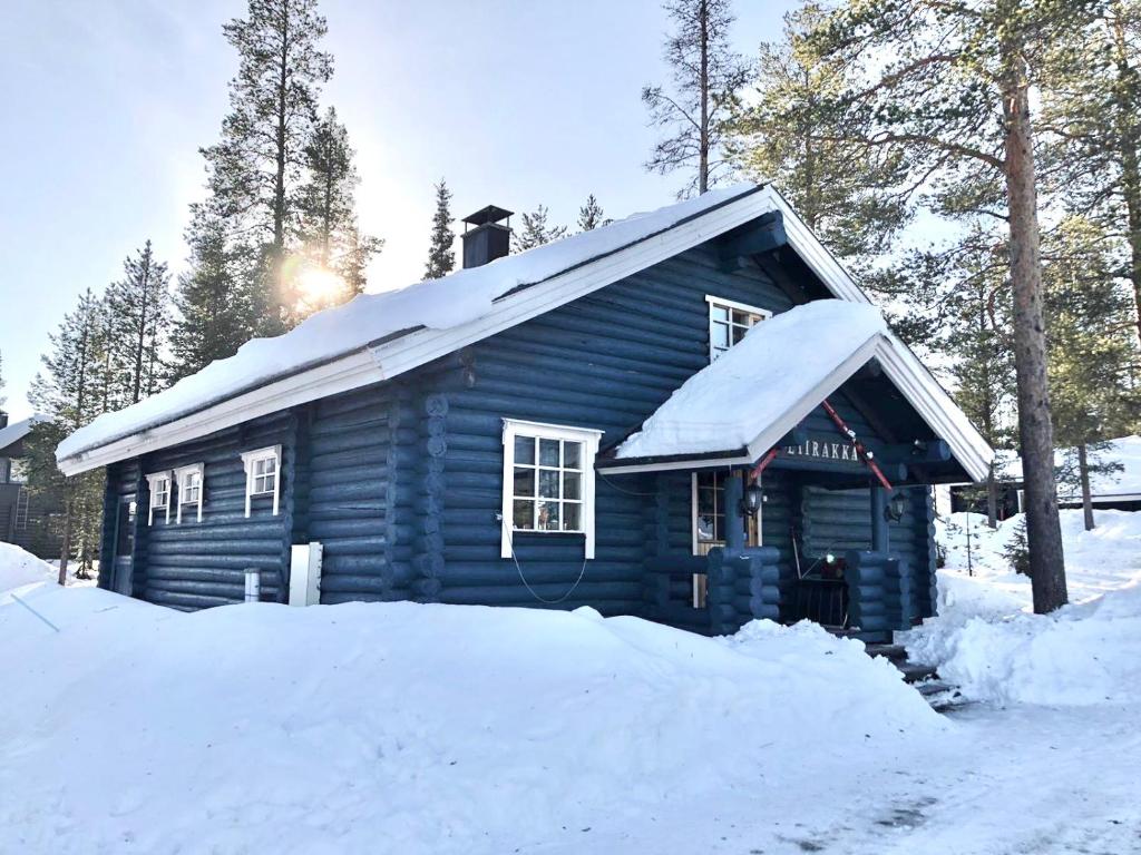 une cabane bleue en rondins recouverte de neige dans l'établissement Liirakka Levi, à Levi