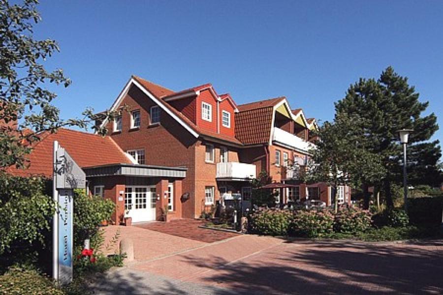 a large brick house with a driveway in front of it at Hotel-Pension Störtebeker in Bensersiel