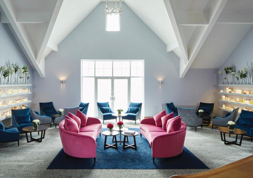 a waiting room with pink chairs and tables at Formby Hall Golf Resort & Spa in Southport